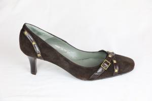 Zapato tacón mediano con adorno metálico y hebilla.